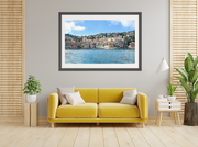 Yellow sofa in a living room with a framed picture of a coastal scene on the wall.