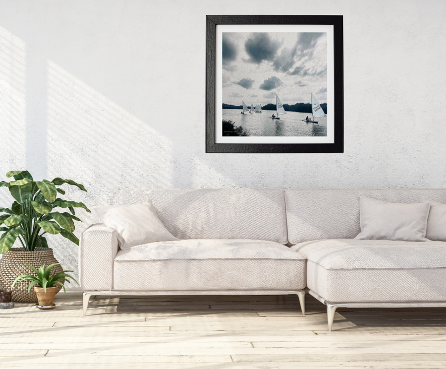 Framed artwork above a white sofa in a minimalistic living room.