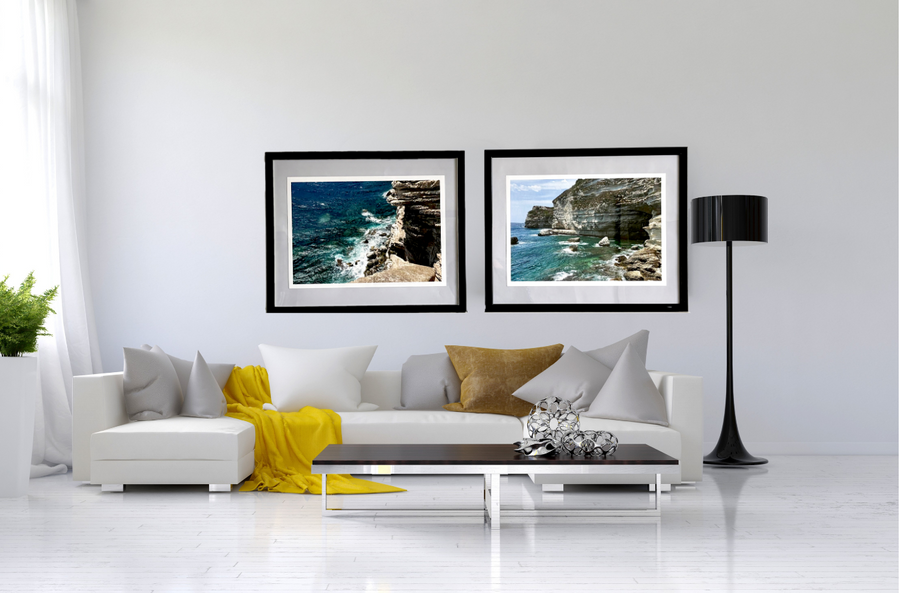 Modern living room with a white sofa, decorative pillows, and framed pictures on the wall.