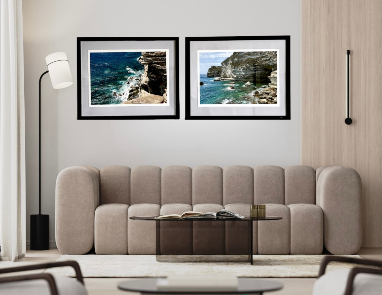 Two framed coastal landscapes above a beige sofa in a living room.