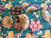 A vibrant wrapping paper featuring traditional Indian sweets like ladoos, barfi, and jalebis on a rich teal wooden background. Decorated with jasmine flowers and intricate details, this seamless pattern adds a festive, cultural touch, perfect for celebrations.