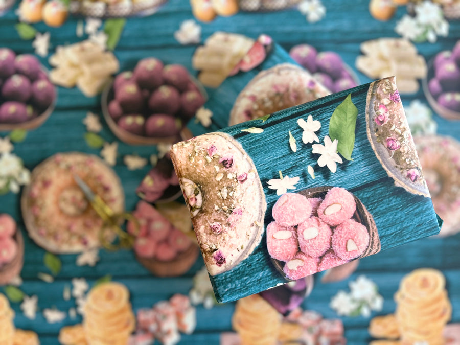 A vibrant wrapping paper featuring traditional Indian sweets like ladoos, barfi, and jalebis on a rich teal wooden background. Decorated with jasmine flowers and intricate details, this seamless pattern adds a festive, cultural touch, perfect for celebrations.