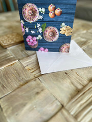 A vibrant greeting card featuring traditional Indian sweets like ladoos, barfi, and jalebis on a rich teal wooden background. Decorated with jasmine flowers and intricate details, this seamless pattern adds a festive, cultural touch, perfect for celebrations.