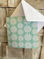 Greeting card inspired by Sindhi Ajrak block printing. Intricate white geometric & floral motifs on mint-green background. The repeating symmetrical pattern reflects traditional craftsmanship with a modern twist.Wrapping paper also available.