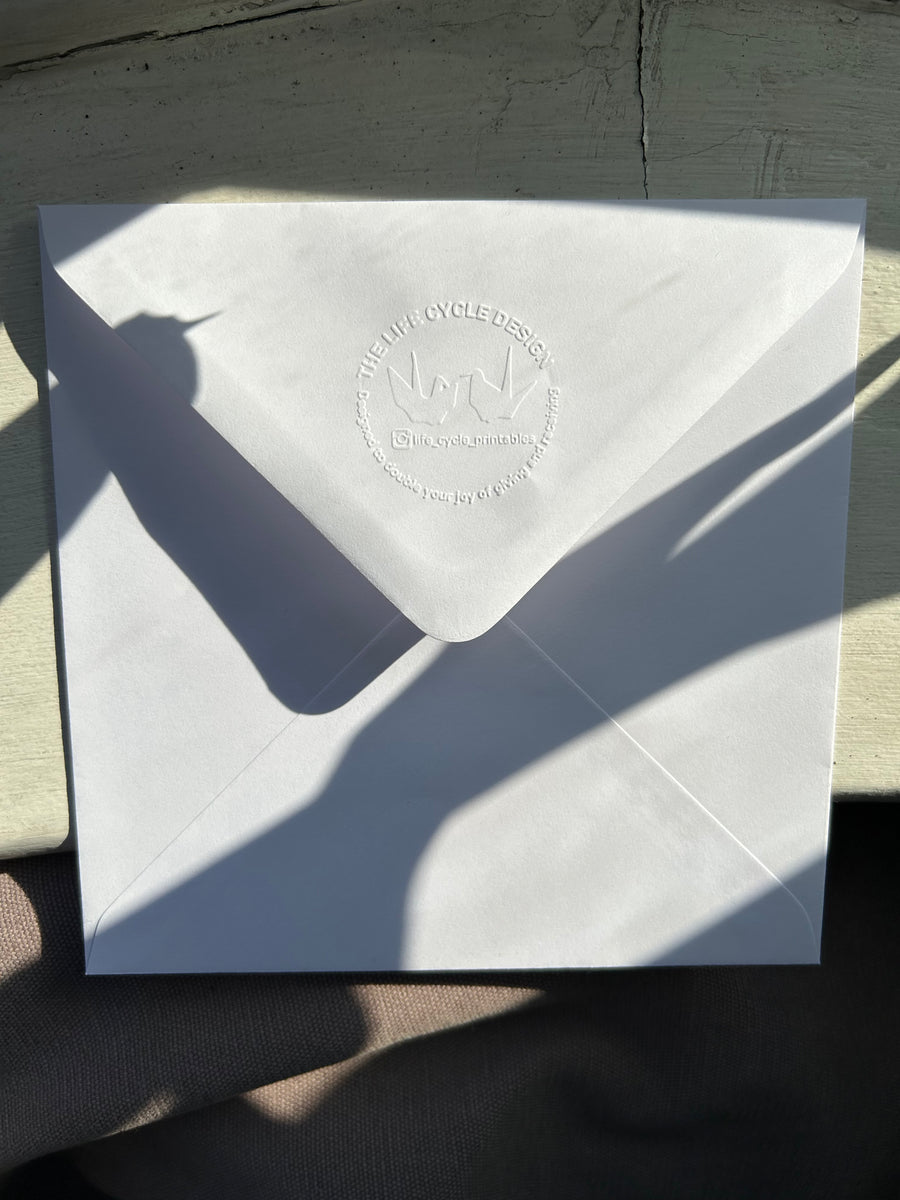 Hand-embossed recycled white accompanying envelope.