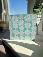 Greeting card inspired by Sindhi Ajrak block printing. Intricate white geometric & floral motifs on mint-green background. The repeating symmetrical pattern reflects traditional craftsmanship with a modern twist.Wrapping paper also available.