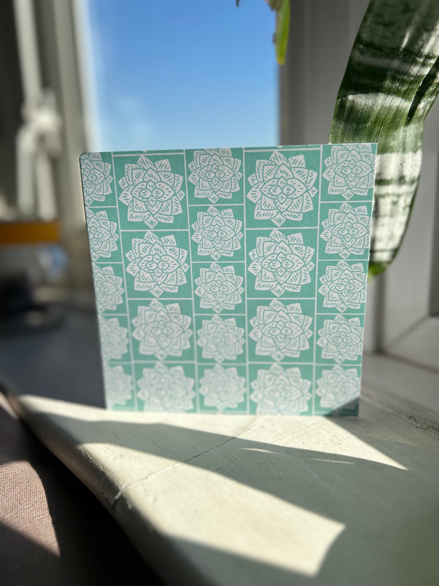 Greeting card inspired by Sindhi Ajrak block printing. Intricate white geometric & floral motifs on mint-green background. The repeating symmetrical pattern reflects traditional craftsmanship with a modern twist.Wrapping paper also available.