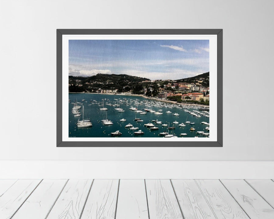 Framed photograph of the Lerici harbor in Italy on a white wall.