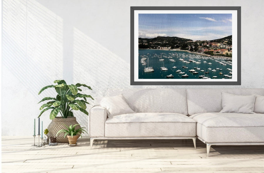 Framed print of Lerici harbour in Italy, on a wall above a white sofa