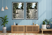 A styled interior scene with two framed River Thames shimmer landscape prints by Seafoam Atelier photographer, Samira Malik  hanging on a light blue paneled wall above a wooden sideboard.