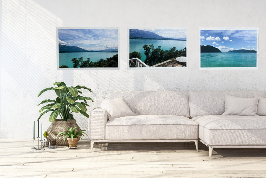 Living room with a white sofa and three framed pictures of a lake on the wall.